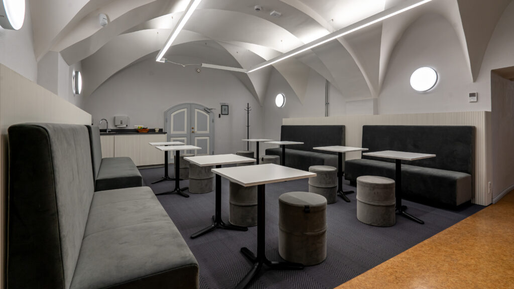 Valgete laudade ja hallide tumbadega puhkeruum